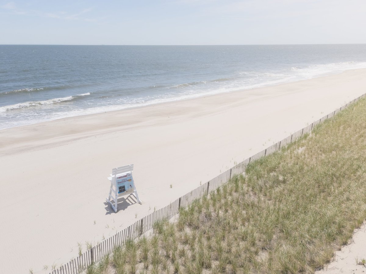 A lifeguard stand sits on the beach by the Atlantic Ocean, ready for the summer season