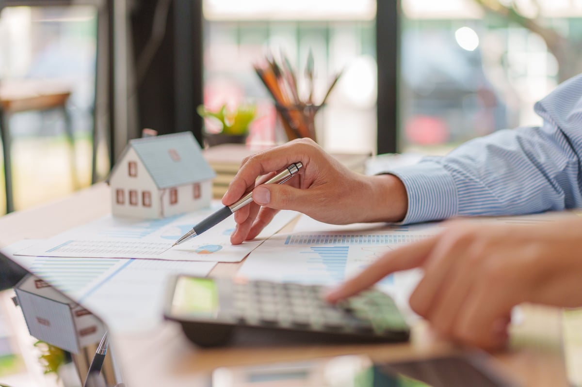 Professional reviewing mortgage and real estate documents at desk